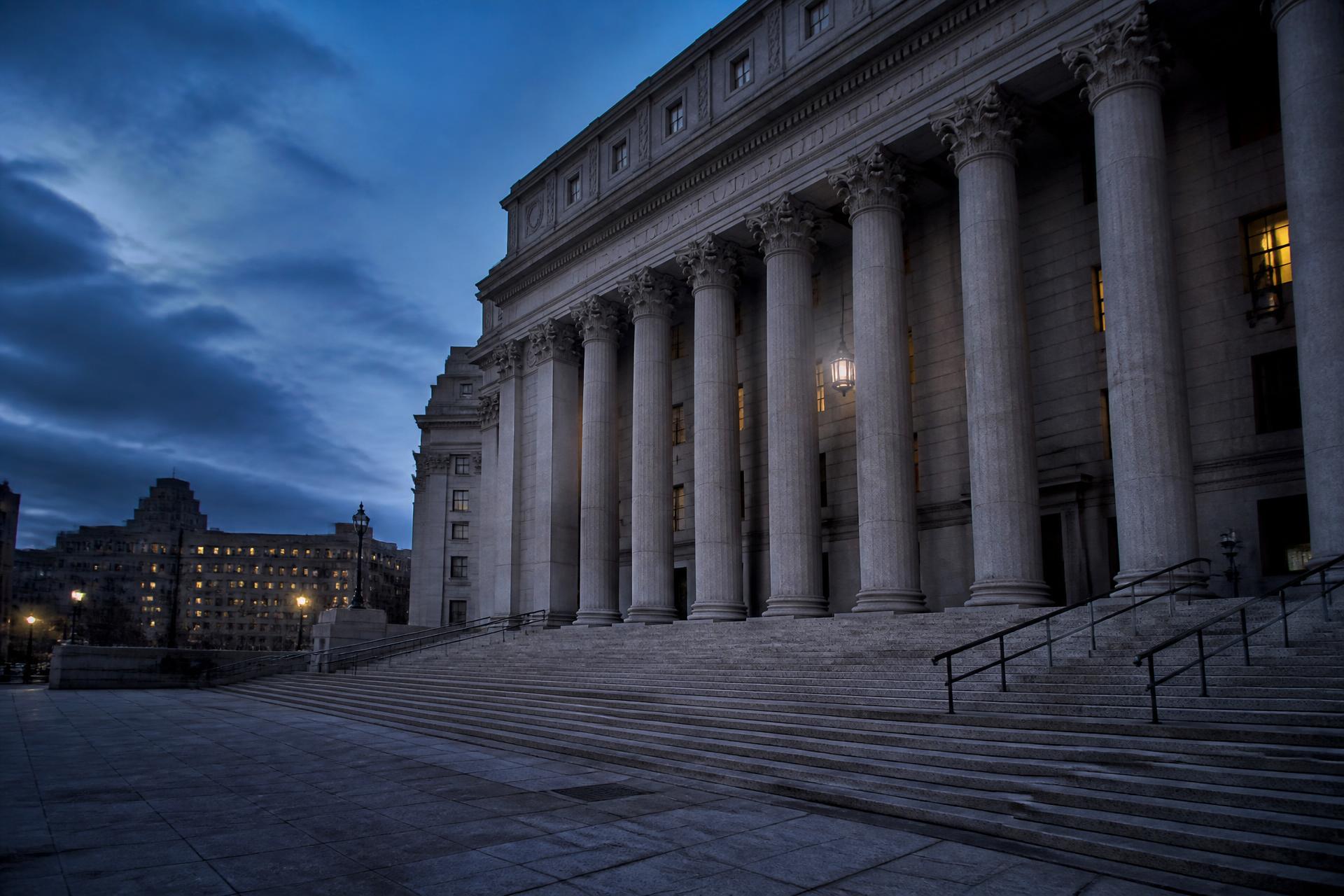 Courthouse exterior with stone columns at dusk